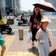 People wearing sun-protective caps walk in the sun on a hot day amid an orange alert for heatwave, in Beijing, China June 16, 2023. REUTERS/Flonrece Lo